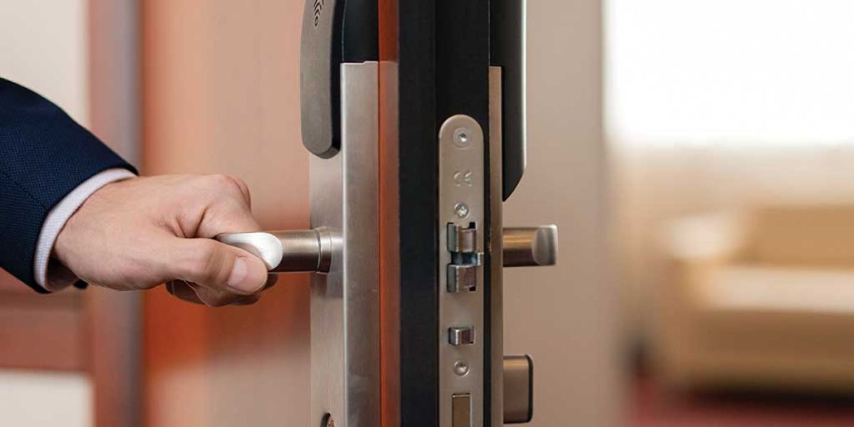 human hand holding handle wooden door while entering one hotel room arrival city during business travel d2111a3b